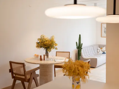 Modern Scandinavian living room with minimalist decor, wooden furniture, and a white leather sofa.
