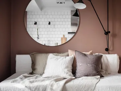 A minimalist bedroom featuring linen bedding and subtle brown walls