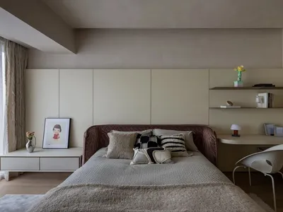 Minimalist bedroom featuring upholstered fabric bed, floating shelves, and wooden furniture.