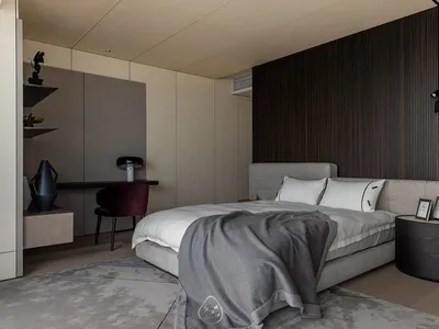 Modern bedroom featuring grey flooring with a textured wood pattern, a grey upholstered bed with white bedding, and a minimal
