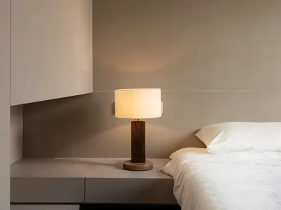Minimalist bedroom with wooden bed and cloth mattress, showcasing modern interior design elements.