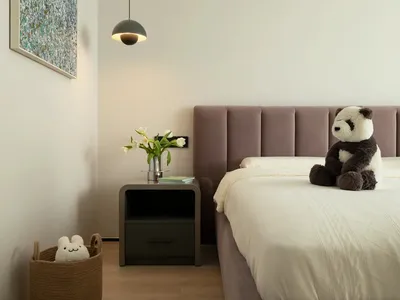 Modern minimalist bedroom with a purple upholstered bed, floating grey pendant light, and minimalistic decor.