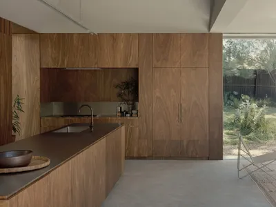 A modern residential kitchen with wooden cabinets and a large island.