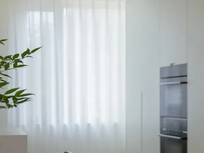 Modern kitchen with wooden furniture and glass windows, featuring contemporary design elements and sleek appliances.
