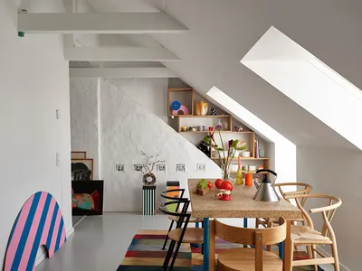 A colorful dining room with a wooden table and various decorative items on the shelves.