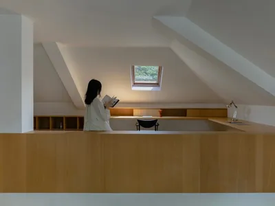 A modern home office with a wooden counter and a skylight.