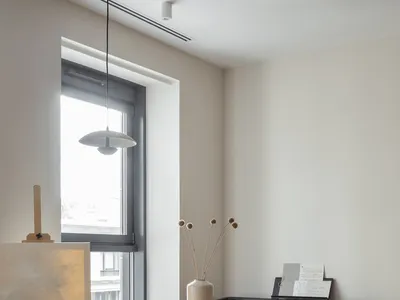 A modern home office featuring a wooden floor, table, chair, and piano.