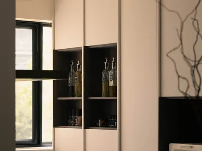 Modern kitchen featuring white and black shelves with various bottles and jars.