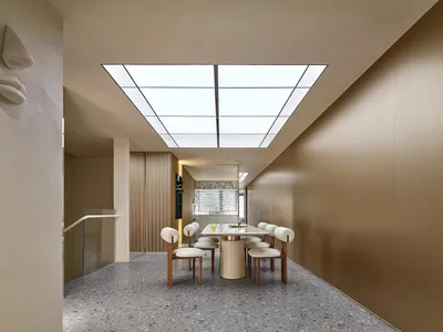 當代簡約風格餐廳，配有長方形餐桌與白色餐椅，置於天窗天花板下方