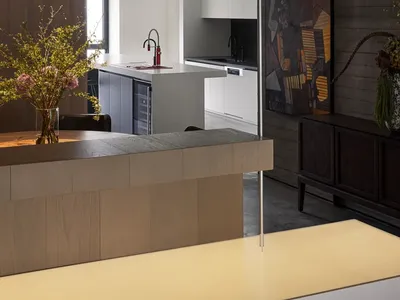 Modern kitchen with wooden island, metal accents, and glass surfaces.