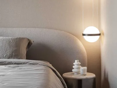 A contemporary bedroom with minimalist design featuring pendant lights and a upholstered bed.