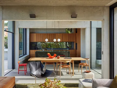 A modern kitchen with wood cabinets and a concrete floor.