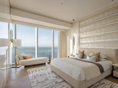 Modern minimalist bedroom with fabric bedding, wooden floor, and metal accents.