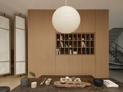一間現代書房，強調木質元素、搭配大型球形燈具，以及擺放各式物品的桌面。