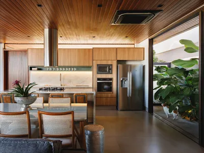 A modern kitchen with white marble countertops and wood cabinets.