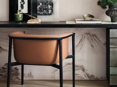 A modern home office featuring a sleek desk, minimalist chair, and stylish decor.