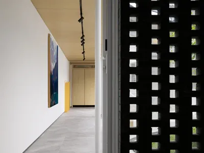 A modern bedroom featuring minimalist design with concrete flooring and walls.