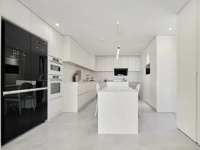 A modern kitchen features elegant marble countertops and white cabinets.