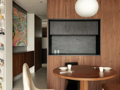 A modern kitchen featuring wooden elements, with a round dining table and chairs.