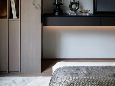 Minimalist bedroom with metal plant holder, concrete floor lamp, and concrete flooring.