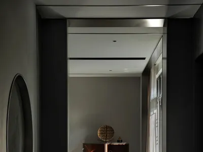 Modern home office with metallic finishes, featuring a sleek desk and minimalist chair.