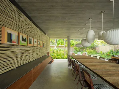 A modern restaurant interior featuring wooden tables, concrete walls, and plants.