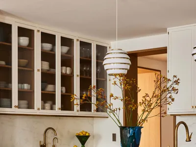 Modern, minimalist kitchen featuring green ceramic tile backsplash and marble countertops.