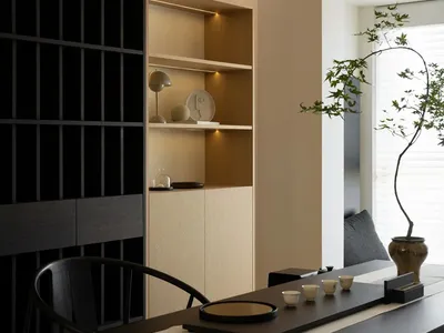 Modern home office featuring a wooden desk and shelving unit with abstract sculptures and lighting.