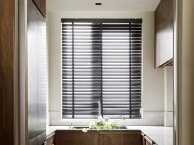 Modern kitchen with marble countertops and wood cabinets.