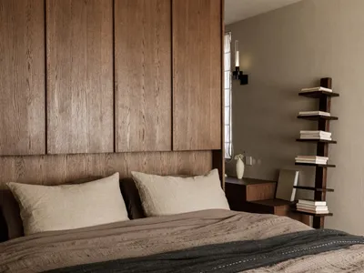 Modern minimalist bedroom featuring a brown bed with wooden headboard, shelves, and books.