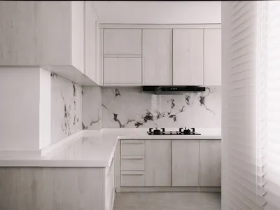 Minimalist kitchen featuring a white marble countertop and white cabinets.