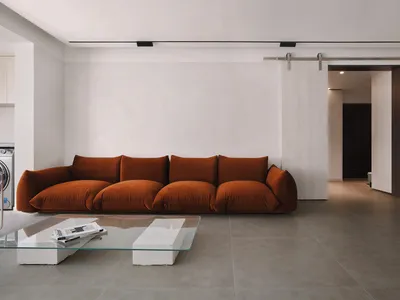 Modern, spacious living room featuring a sleek, minimalist design with rich colors, and large windows allowing natural light