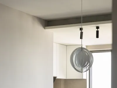 A modern kitchen with wood countertops, leather chairs, and marble backsplash.