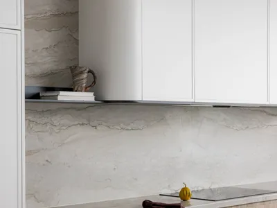 Modern kitchen featuring minimalist design with marble countertops and cabinets.