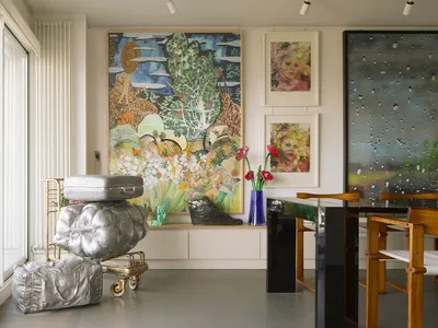 A modern home office with an art collection featuring abstract paintings and sculptures.