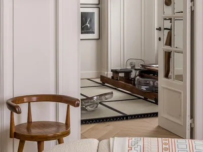 A modern home office featuring wooden shelves with glass and metal elements.