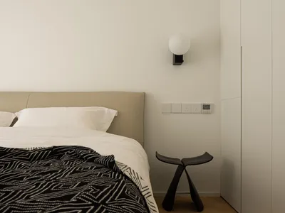 Cushioned headboard and wooden floor in minimalist bedroom setting