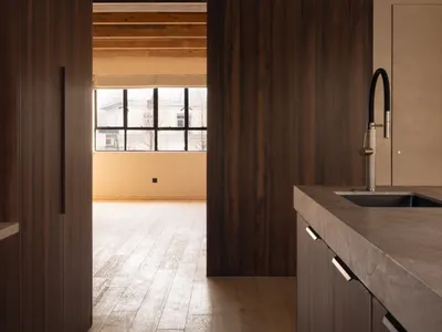 Modern kitchen interior with wooden flooring and cabinetry.