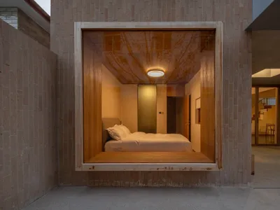 Modern minimalist bedroom with a floating platform bed made of wood, featuring a sleek design with concealed lighting and a m