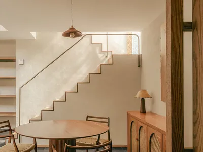 現代室內空間，設有酒吧、廚房與早餐角，搭配木質家具與混凝土地板。