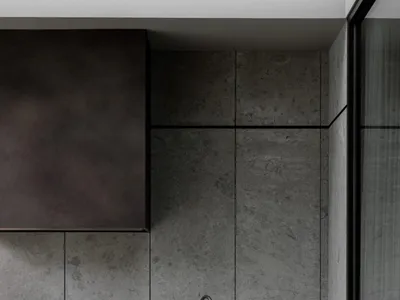 A minimalist kitchen featuring a sleek black steel countertop and a minimalist faucet.
