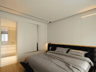 Modern bedroom with white walls and neutral bedding.
