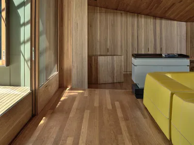A modern industrial living room with wooden paneling and furniture.