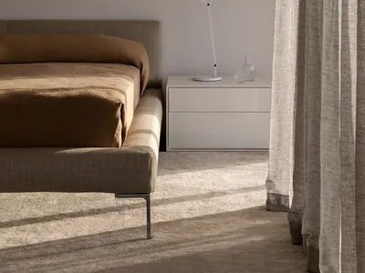 Modern minimalist bedroom featuring a grey fabric bed, a white floating nightstand, and sheer curtains allowing soft light to