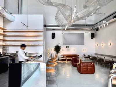 A modern restaurant with a metal and glass ceiling art installation