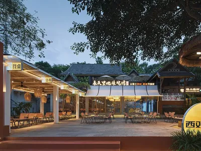 餐廳戶外座位區，鋪設混凝土地面、木製餐桌，以及玻璃遮陽傘。