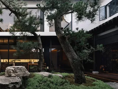 An elegant, modern restaurant interior with concrete flooring and a minimalist design.