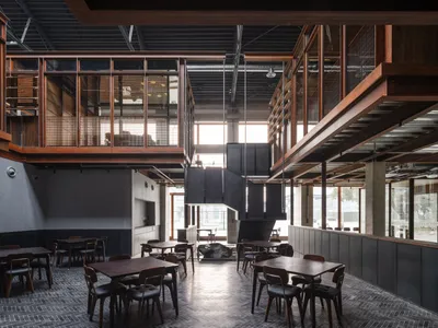 A modern restaurant interior featuring industrial elements such as wood, metal, and glass.