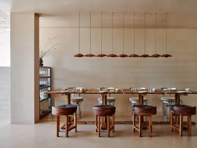Modern restaurant interior with wooden furniture and a minimalist design.
