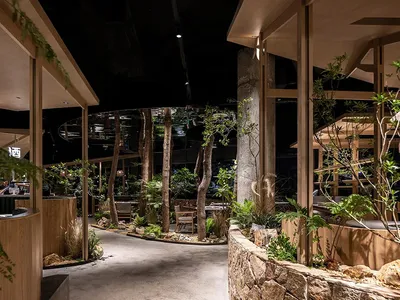 A restaurant interior with exposed wood, concrete, and stone elements.